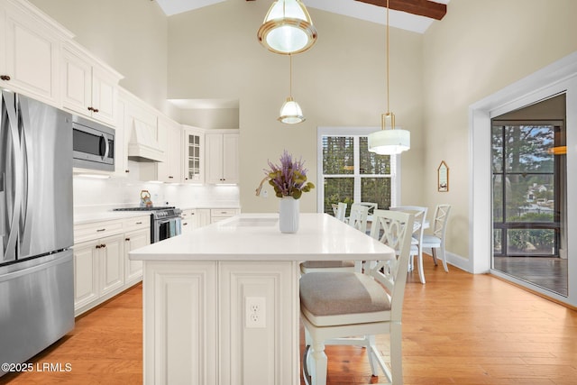 222 Hampton Lake Dr, Bluffton, SC 29910 - kitchen with glass insert cabinets, high vaulted ceiling, a kitchen bar, light countertops, and appliances with stainless steel finishes