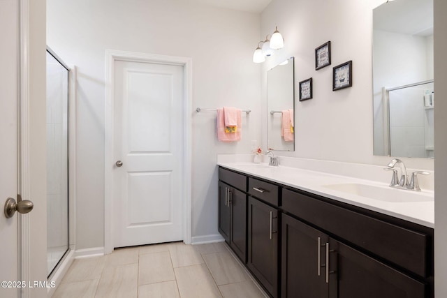 full bath with a shower with door, double vanity, and a sink