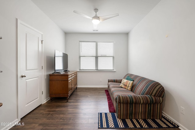 living area with dark wood-type flooring, visible vents, baseboards, and ceiling fan