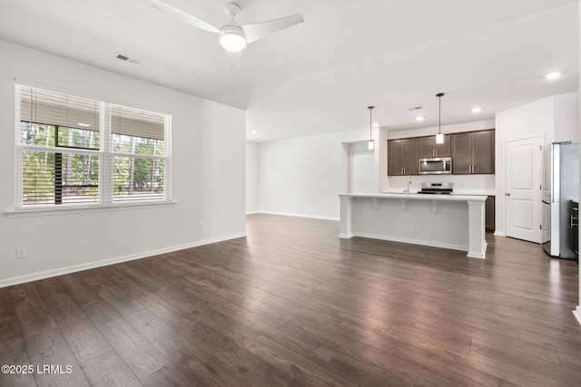 unfurnished living room with a sink, dark wood-type flooring, recessed lighting, and visible vents