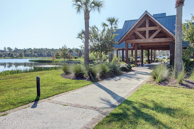 view of home's community with a water view and a yard