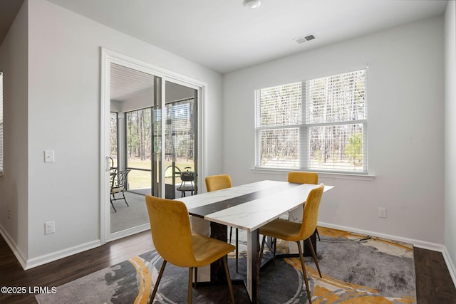 dining space featuring wood finished floors, visible vents, a wealth of natural light, and baseboards