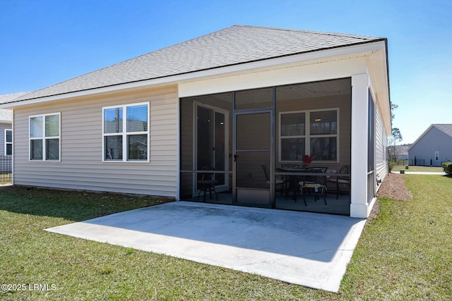 back of house featuring a patio area, a lawn, roof with shingles, and a sunroom