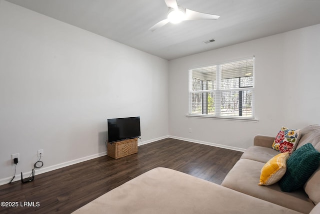 living area featuring ceiling fan, visible vents, baseboards, and wood finished floors