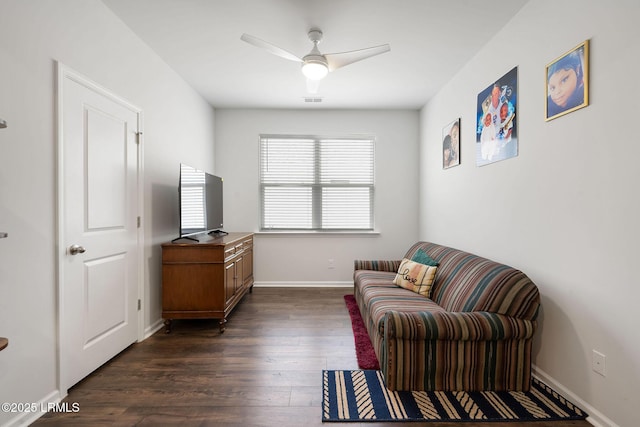 living area with dark wood finished floors, visible vents, baseboards, and ceiling fan