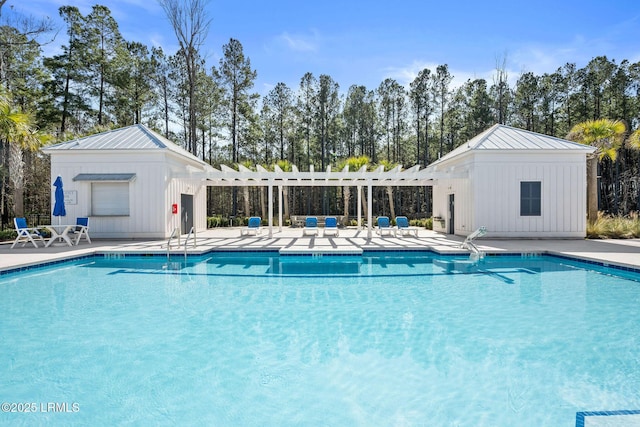 community pool featuring an outbuilding, a patio area, and a pergola