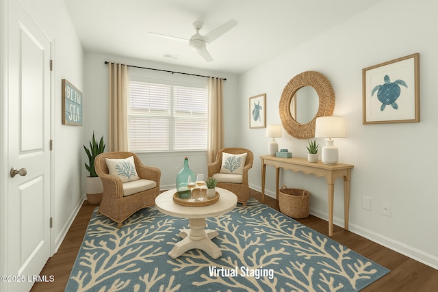 living area featuring baseboards, ceiling fan, and dark wood-type flooring