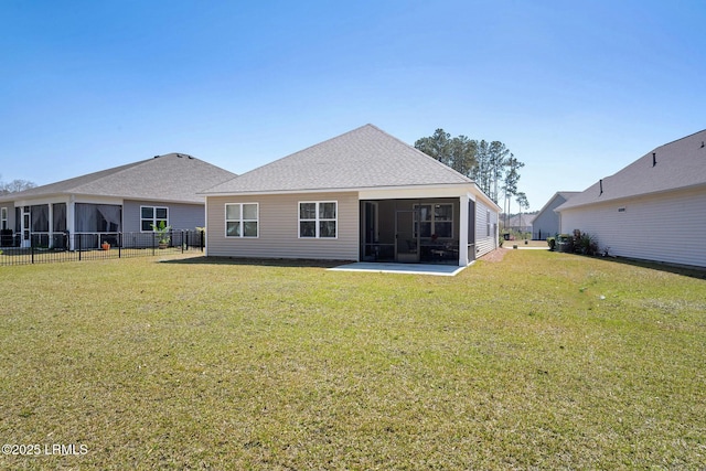 rear view of property with a sunroom, a lawn, fence, and roof with shingles