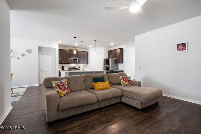 living room featuring baseboards, ceiling fan, and dark wood-style flooring