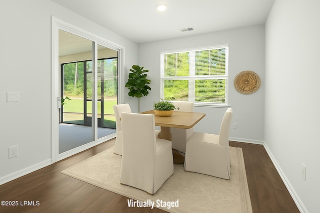 dining area with baseboards, wood finished floors, and visible vents