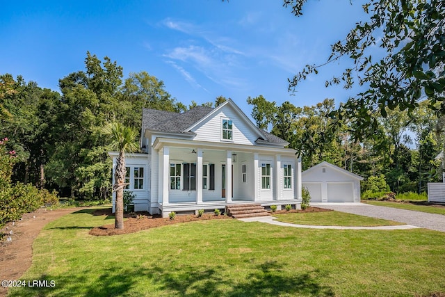 greek revival house featuring a garage, an outbuilding, covered porch, and a front lawn