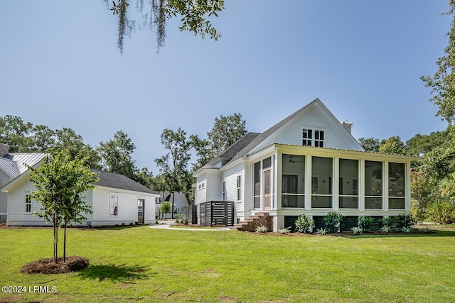 back of property featuring a yard and a sunroom