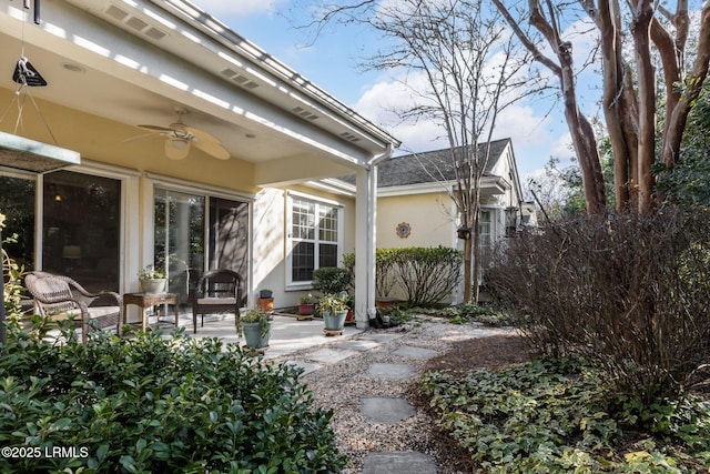 exterior space featuring a patio area, fence, a ceiling fan, and stucco siding