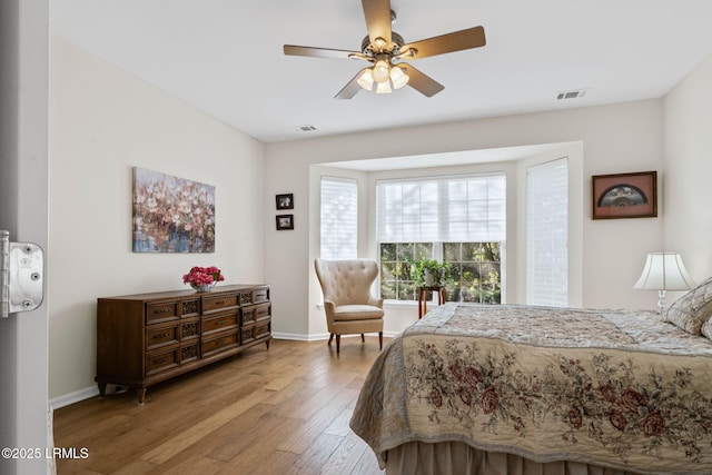 bedroom with light wood-style flooring, visible vents, and baseboards