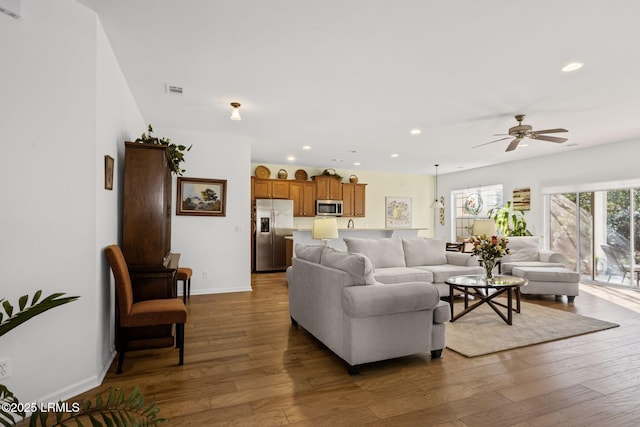 living area with recessed lighting, wood-type flooring, and baseboards