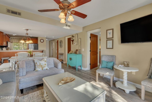 living room with ceiling fan and light hardwood / wood-style flooring