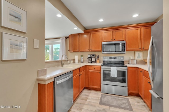 kitchen featuring stainless steel appliances, sink, and light wood-type flooring