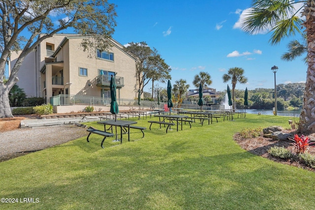 view of community featuring a water view and a lawn