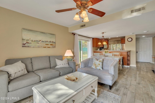 living room featuring ceiling fan and light hardwood / wood-style flooring