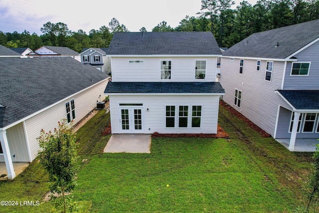 back of house with french doors, a patio area, and a lawn