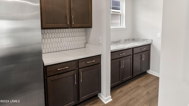 kitchen with hardwood / wood-style flooring, stainless steel fridge, and dark brown cabinets