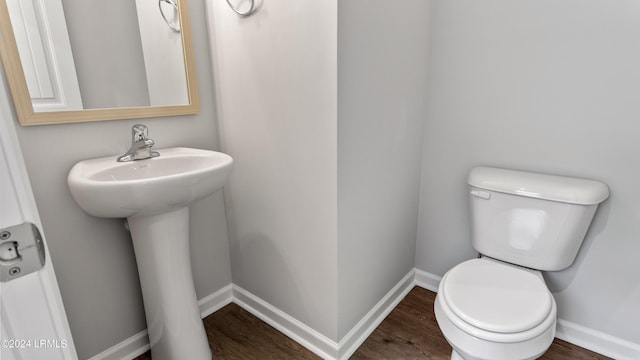 bathroom featuring wood-type flooring, toilet, and sink