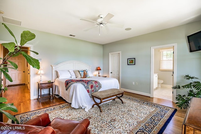 bedroom featuring dark hardwood / wood-style flooring, connected bathroom, and ceiling fan