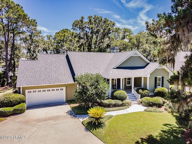 view of front facade with a garage, a front yard, and covered porch