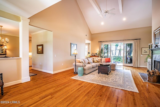 living room with ceiling fan, high vaulted ceiling, ornamental molding, light hardwood / wood-style floors, and ornate columns