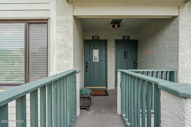 view of exterior entry with a balcony