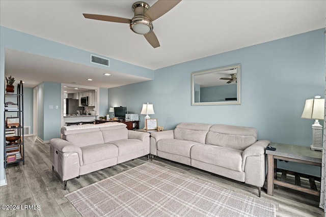 living room with hardwood / wood-style floors and ceiling fan