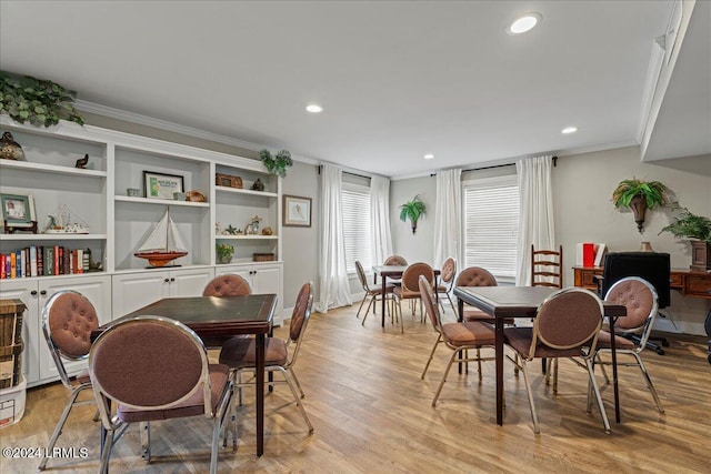 dining area with ornamental molding and light hardwood / wood-style floors