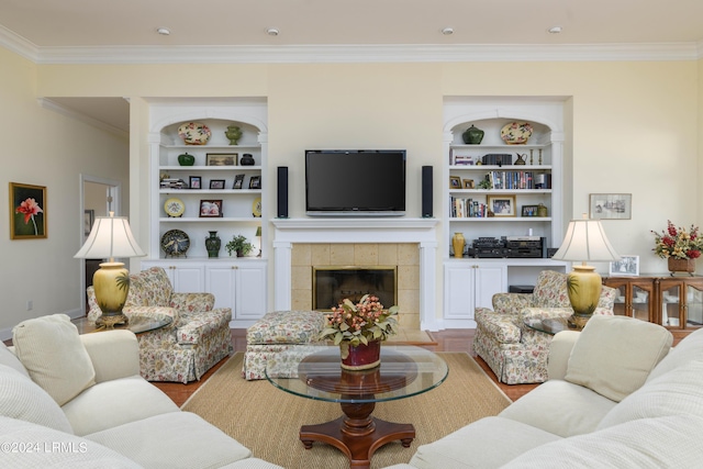 34 Osprey Cir, Okatie, SC 29909 - living room featuring a tiled fireplace, crown molding, light hardwood / wood-style flooring, and built in shelves