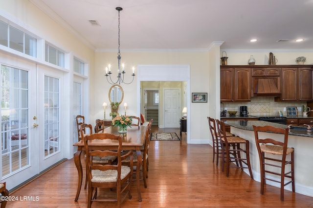 34 Osprey Cir, Okatie, SC 29909 - dining space with hardwood / wood-style flooring, ornamental molding, and an inviting chandelier