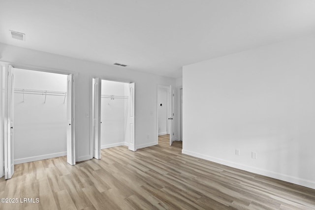 53 Salt Marsh Dr, Hilton Head Island, SC 29926 - unfurnished bedroom with light wood-style floors, baseboards, and multiple closets