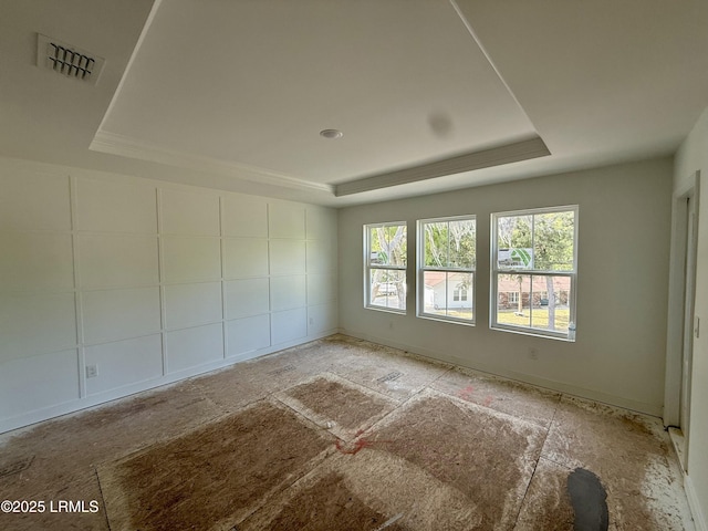 spare room with a raised ceiling and visible vents