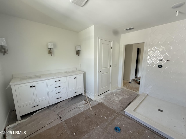 full bath featuring baseboards, visible vents, and tiled shower
