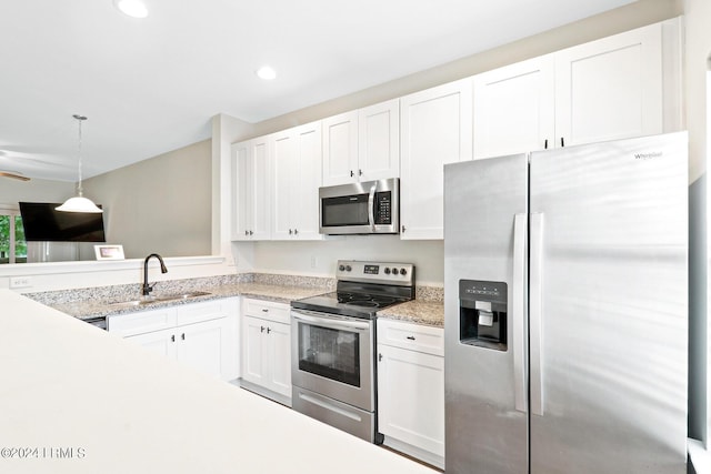 kitchen featuring white cabinetry, stainless steel appliances, decorative light fixtures, and sink