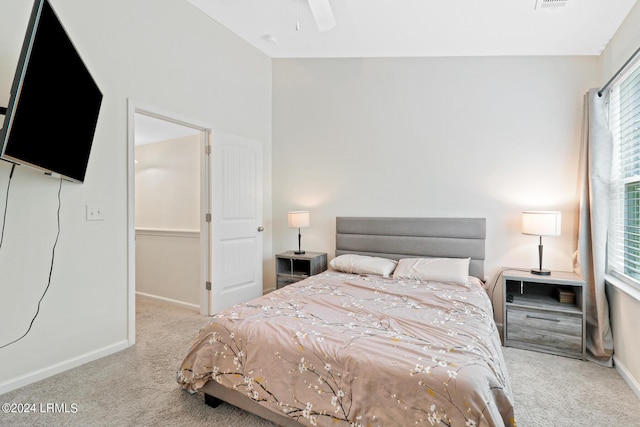 carpeted bedroom with ceiling fan and multiple windows