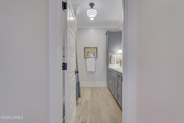 corridor featuring light wood-style flooring and baseboards