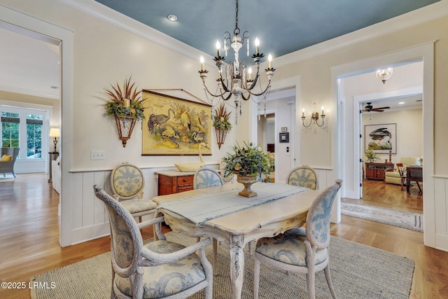 dining area featuring a wainscoted wall, light wood-style flooring, and crown molding