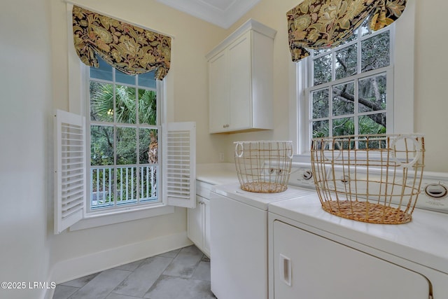 laundry area with cabinet space, washing machine and dryer, baseboards, and ornamental molding