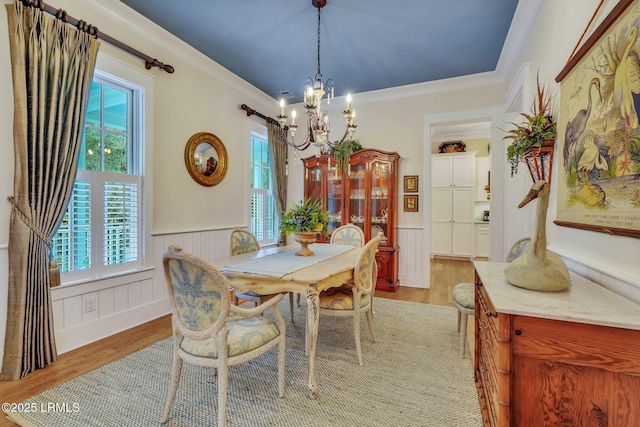 dining room featuring a wealth of natural light, light wood-type flooring, and wainscoting