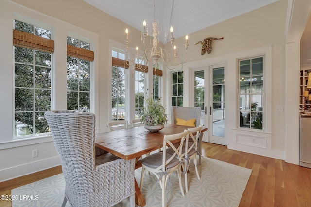 sunroom / solarium featuring a wealth of natural light, a chandelier, and french doors