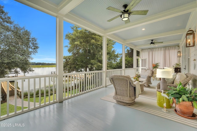 sunroom / solarium with a wealth of natural light, a water view, beam ceiling, and ceiling fan