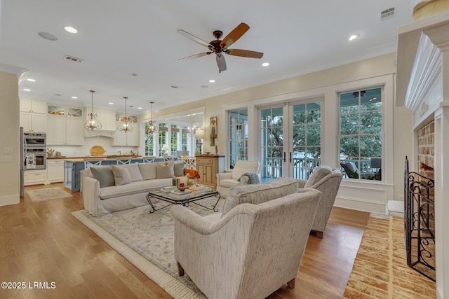 living area featuring visible vents, light wood-style flooring, and french doors