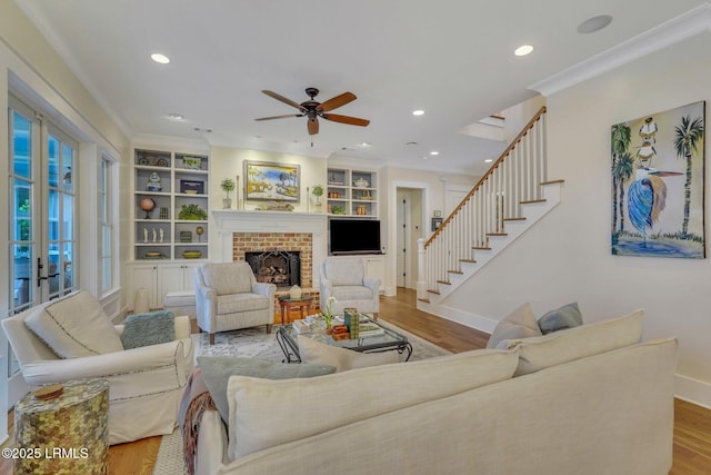 living room with stairs, baseboards, wood finished floors, and crown molding