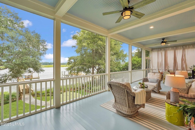 sunroom with beam ceiling, ceiling fan, and a water view