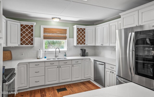 79 Lost Island Rd, Beaufort, SC 29907 - kitchen featuring light countertops, white cabinets, stainless steel appliances, a sink, and wood finished floors