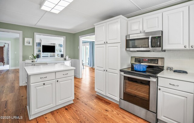 79 Lost Island Rd, Beaufort, SC 29907 - kitchen featuring white cabinets, a center island, light countertops, stainless steel appliances, and decorative backsplash